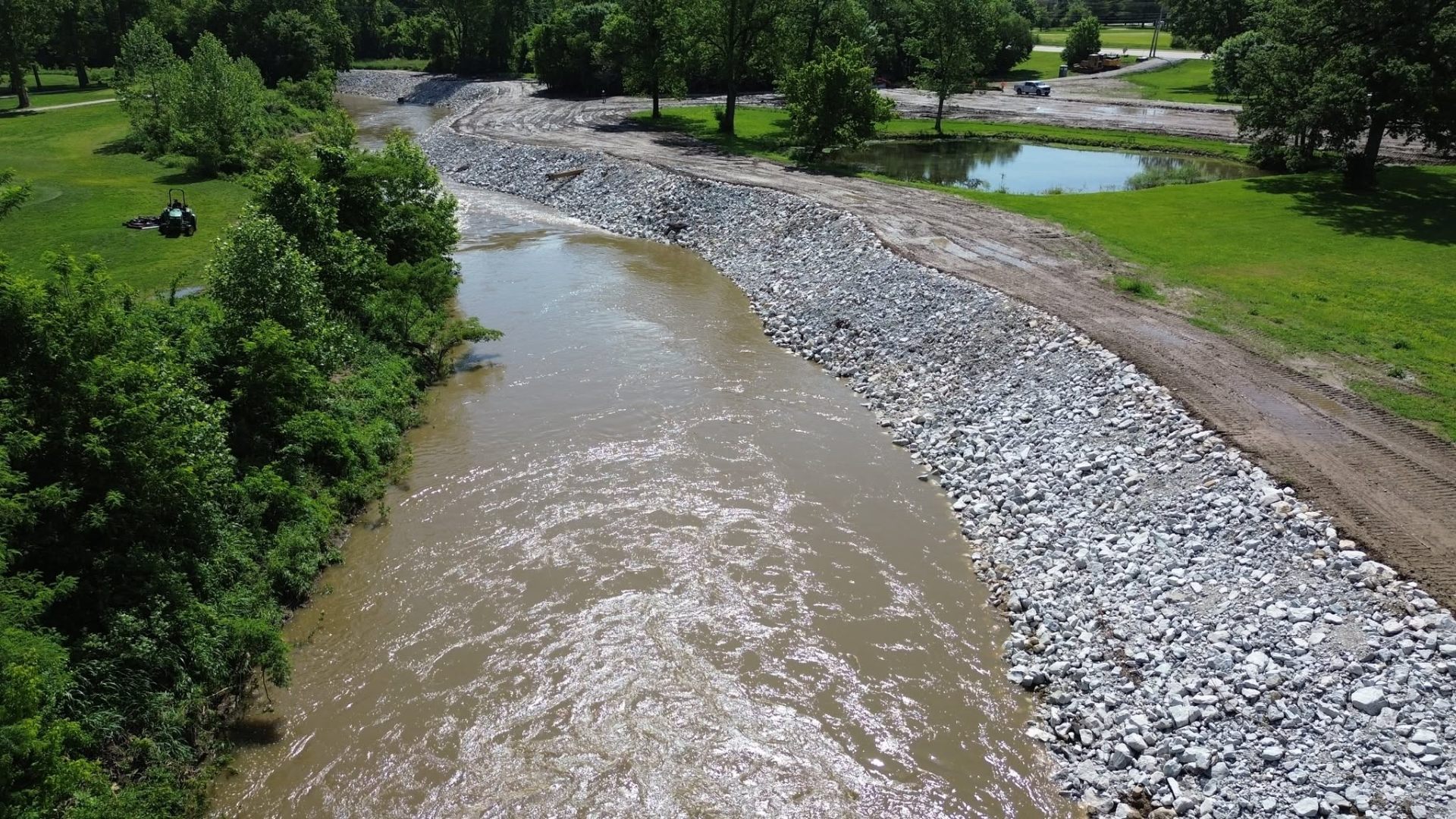 Creek bank rehabilitation with rip-rap stone armoring along an active stream