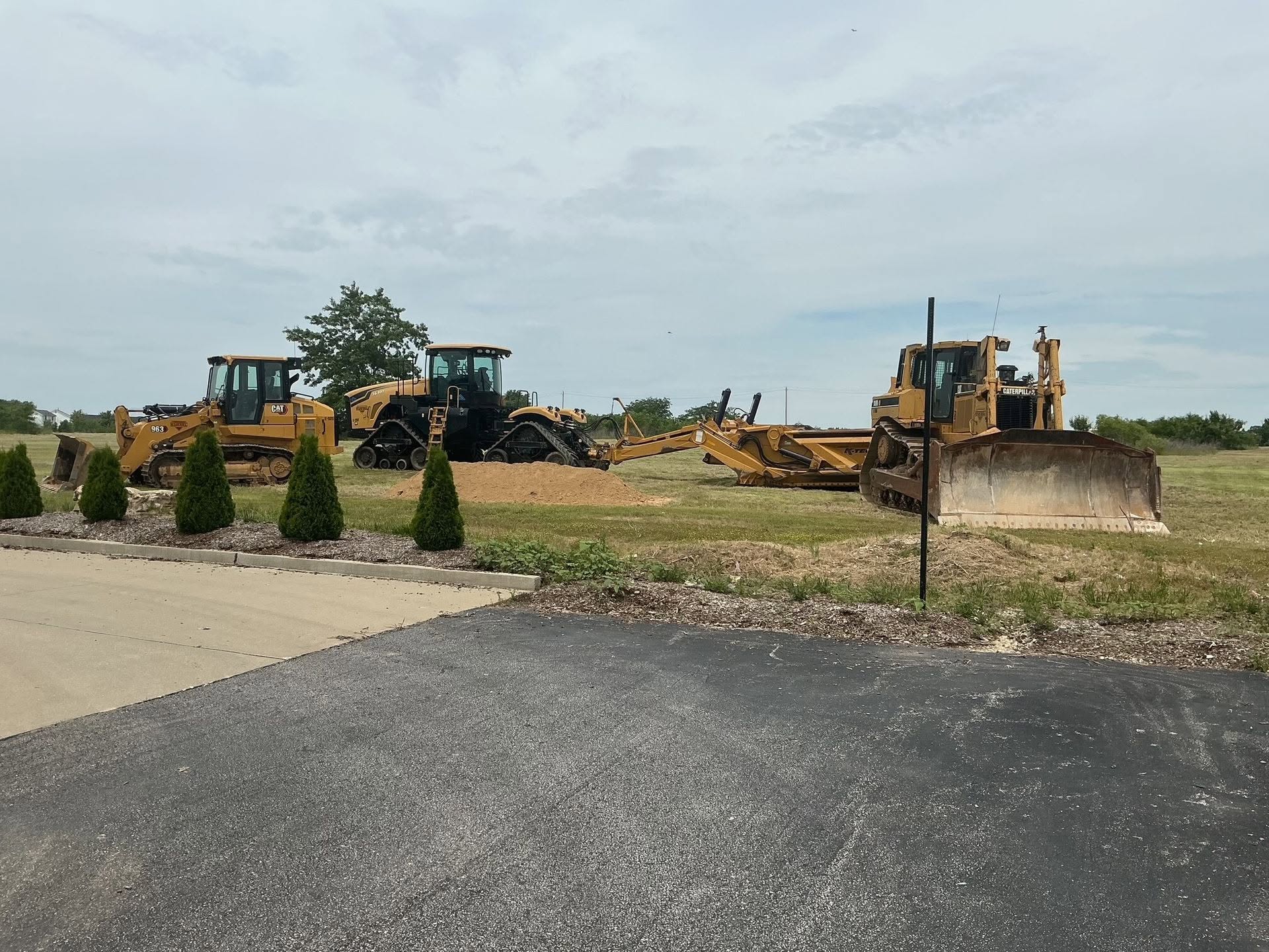 Kuesel heavy equipment lineup — excavators, dozers, articulated trucks, and scrapers mobilized for industrial and commercial sitework across St. Louis